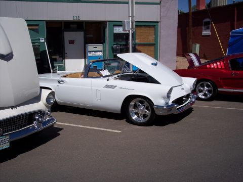 1972 Ford Ranchero - A white 1955 Ford Thunderbird convertible is displayed with its hood open, parked alongside other vehicles.