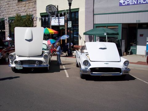 1972 Ford Ranchero - Two white 1955 Ford Thunderbirds are displayed with their hoods open at an outdoor event.