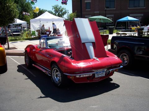1972 Ford Ranchero - A red convertible sports car is parked outside with its hood open, displaying white racing stripes.