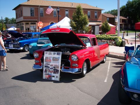 1972 Ford Ranchero - A red 1955 pickup truck is displayed with its hood up, alongside other vehicles at an outdoor event.