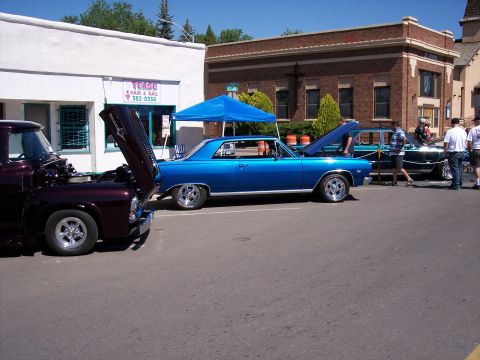 1972 Ford Ranchero - A bright blue coupe, possibly a 1966 model, is displayed with its hood open at an outdoor event.