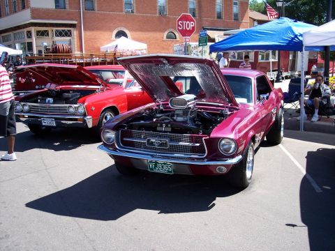 1972 Ford Ranchero - A modified 1967 Ford Mustang is displayed with its hood open, revealing a powerful engine, at an outdoor car show.