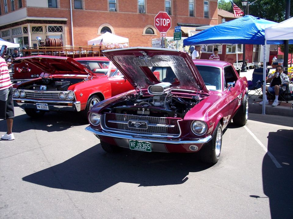 Customized 1967 Ford Mustang with a supercharger, parked next to a red car