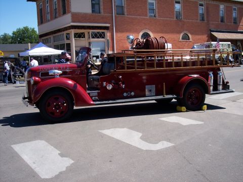 1972 Ford Ranchero - A vintage red fire truck with a hose reel and ladder rack is parked on a street.