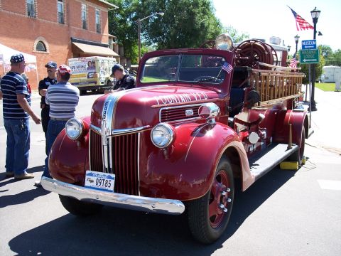 1972 Ford Ranchero - This vintage fire truck, labeled 'FOUNTAIN RED', is parked on a street with onlookers nearby.