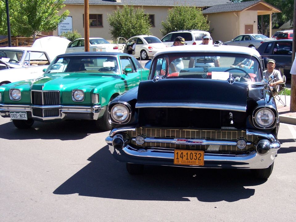 1957 Chevrolet Bel Air front view, parked next to a green car. Colorado license plate 14-1032