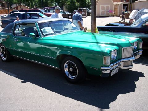 1972 Ford Ranchero - Green 1973 Pontiac Grand Am coupe with black vinyl top parked outside.