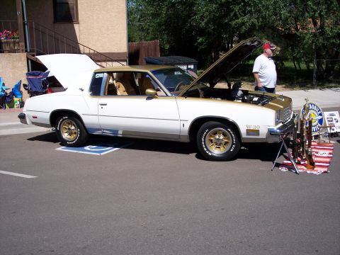 1972 Ford Ranchero - A white and gold Oldsmobile Cutlass is displayed with its hood open, alongside trophies.