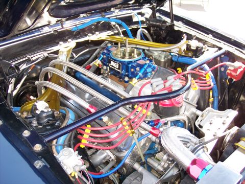 1972 Ford Ranchero - Modified V8 engine bay with performance parts like a BIG3 carburetor and braided fuel lines.