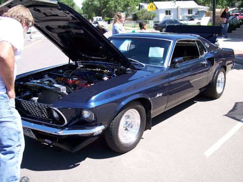 1972 Ford Ranchero - A dark blue 1969 Ford Mustang Mach 1 is displayed with its hood open, revealing the engine bay.