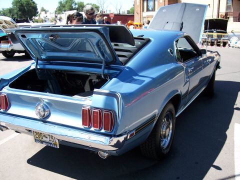 1972 Ford Ranchero - A blue 1969 Ford Mustang is displayed with its trunk open, showing its interior and rear end.