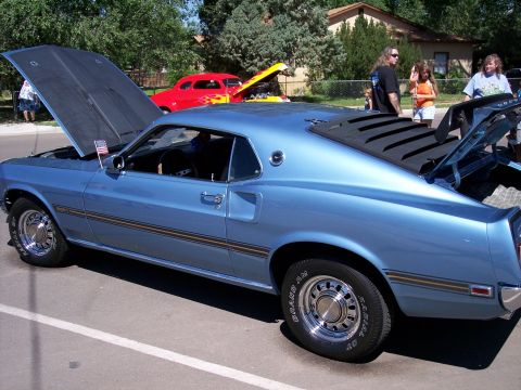 1972 Ford Ranchero - A light blue coupe, possibly a 1969 model, is displayed with its hood and trunk open, alongside other vehicles.