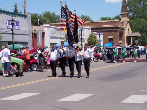 1972 Ford Ranchero - A parade is underway, a red car and participants carrying American flags.