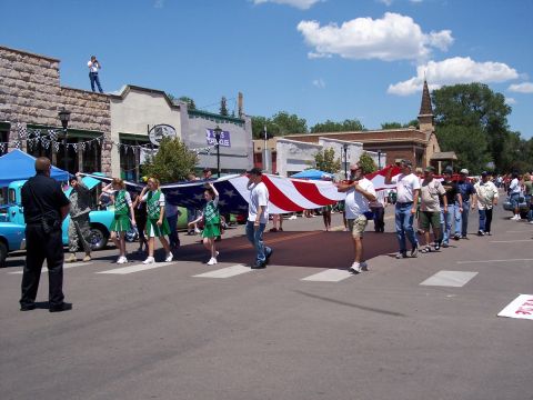 1972 Ford Ranchero - A parade procession moves down a street, with participants carrying a large American flag.