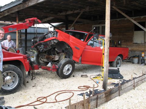 1995 Ford Bronco - A red 1995 Ford Bronco with severe front-end damage is being towed.