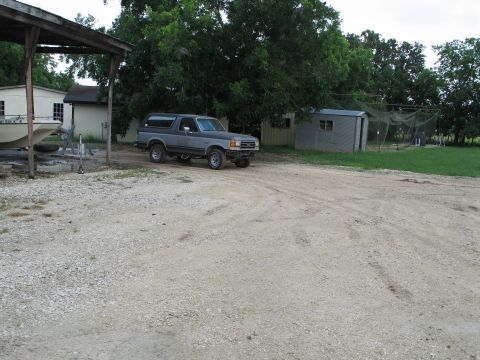 1995 Ford Bronco - This Ford Bronco is parked outside a shed with trees in the background.