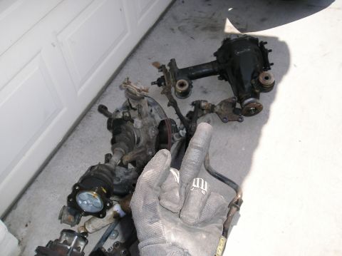 1986 Toyota Hilux - Various vehicle suspension parts and a differential are laid out on the ground.