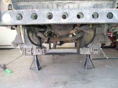 1986 Toyota Hilux - Underside view of a vehicle's front suspension and frame, supported by jack stands.