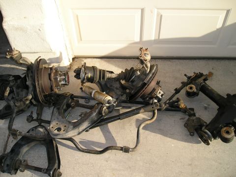1986 Toyota Hilux - Vehicle suspension parts laid out on the ground, likely for repair or replacement.