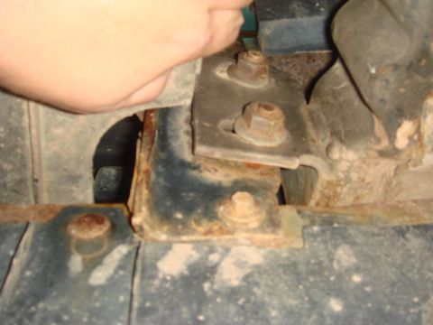 1996 Ford Bronco - Close-up of a rusted metal bracket and bolts, likely part of a winch installation.