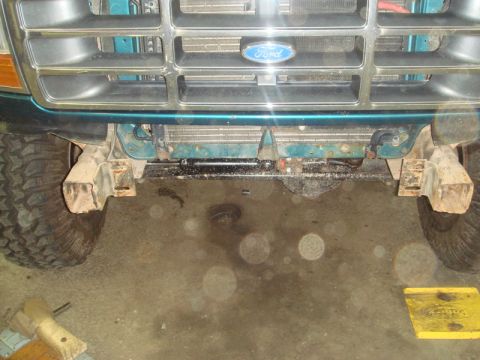 1996 Ford Bronco - Close-up of the front grille and bumper area of a 1996 Ford Bronco, showing the Ford logo and off-road tires.