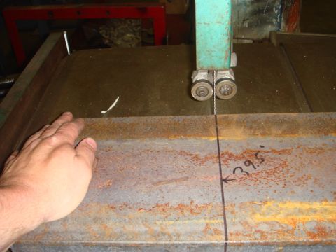 1996 Ford Bronco - A band saw is cutting a piece of metal, with a hand nearby for scale and a measurement marked on the material.