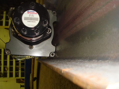 1996 Ford Bronco - Close-up of a Sauer-Danfoss hydraulic motor, part number 328801M095A, mounted on a steel beam.