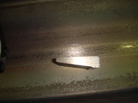 1996 Ford Bronco - A close-up view shows a metal bracket affixed to a grimy, textured surface, possibly part of a vehicle's undercarriage or frame.