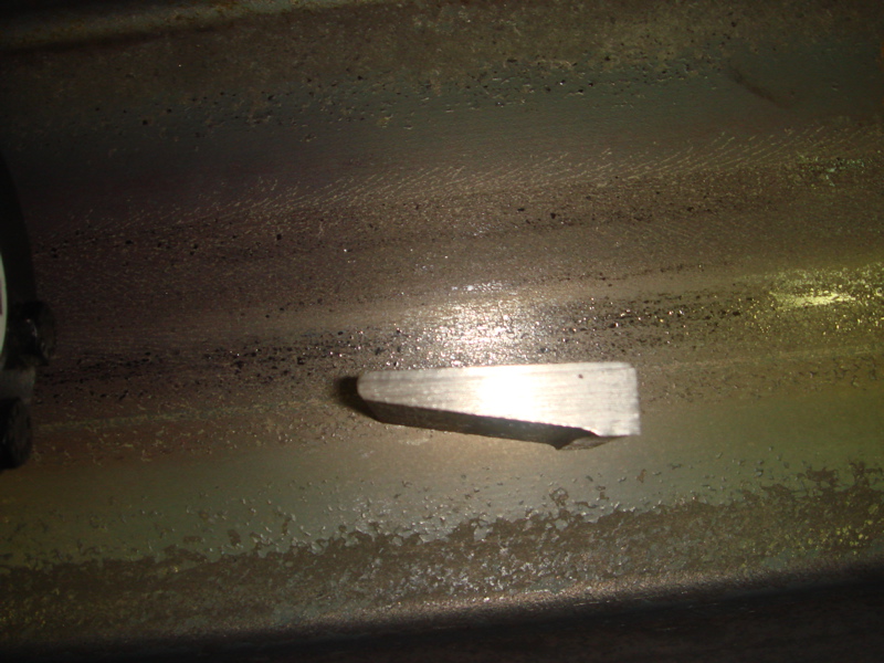 Metal bracket attached to a dirty, textured surface