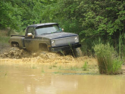 1976 Chevrolet Blazer - Pickup truck navigating a muddy off-road course.