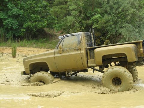 1976 Chevrolet Blazer - Pickup truck stuck in mud and water, showing off its large tires and lifted suspension.