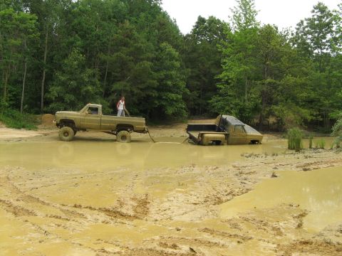 1976 Chevrolet Blazer - A tow truck attempts to extract a stuck truck from a muddy mire.