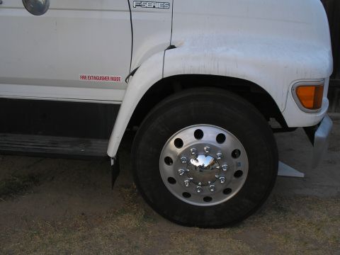 1999 Ford F-800 - A white Ford F-Series truck is shown from the front, focusing on the fender and wheel area.