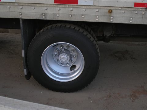 1999 Ford F-800 - Rear wheel and trailer side detail of a large commercial truck.