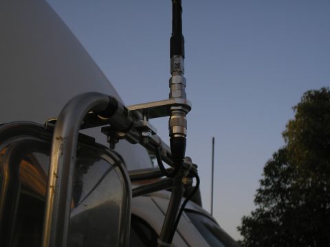1999 Ford F-800 - An antenna mount is attached to the side of a truck, with the sky visible in the background.