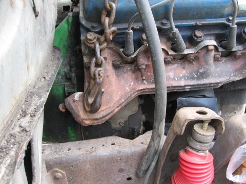 1974 Ford F-100 - Close-up view of an engine bay, a chain hoist attached to the engine block and various engine components.