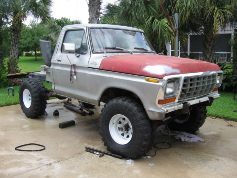 1974 Ford F-100 - A pickup truck is undergoing modifications, with the bed removed and large off-road tires installed.