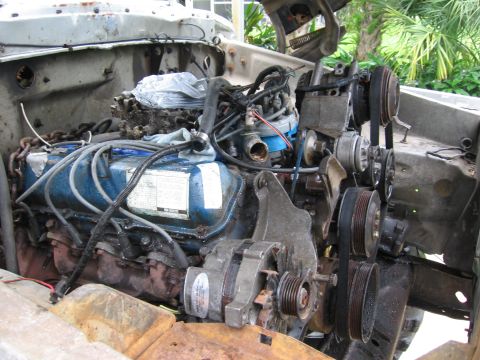 1974 Ford F-100 - Close-up view of a V8 engine in a truck's engine bay, with various components visible.