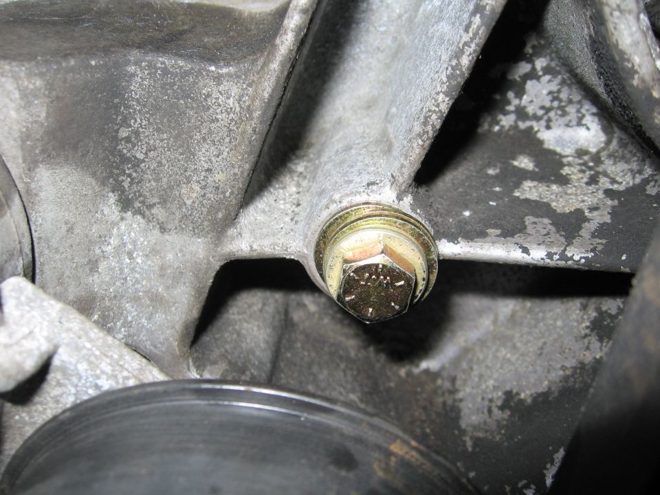 Close-up of a bolt on an engine block, with a pulley visible below