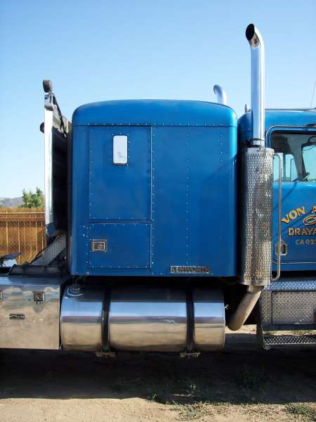 1981 Kenworth W900A - Blue 1981 Kenworth W900A semi-truck cab and fuel tank, seen from the side.