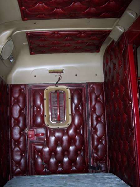 1981 Kenworth W900A - The interior of a truck cab features plush red diamond-tufted upholstery on the walls and ceiling.