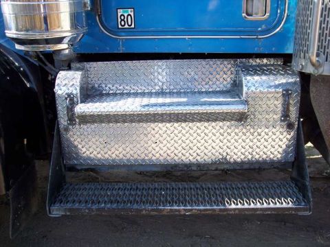 1981 Kenworth W900A - Close-up of the diamond plate steps and lower door panel of a blue semi-truck.