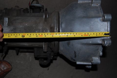1992 Ford Explorer - A yellow tape measure is used to measure a metal transmission part.