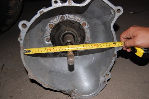 1992 Ford Explorer - A transmission bell housing is measured with a tape measure, indicating its size.
