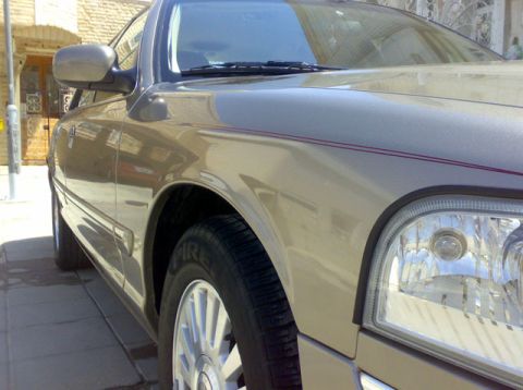 2007 Mercury Grand Marquis - Front quarter view of a tan 2007 Mercury Grand Marquis parked on a paved surface.