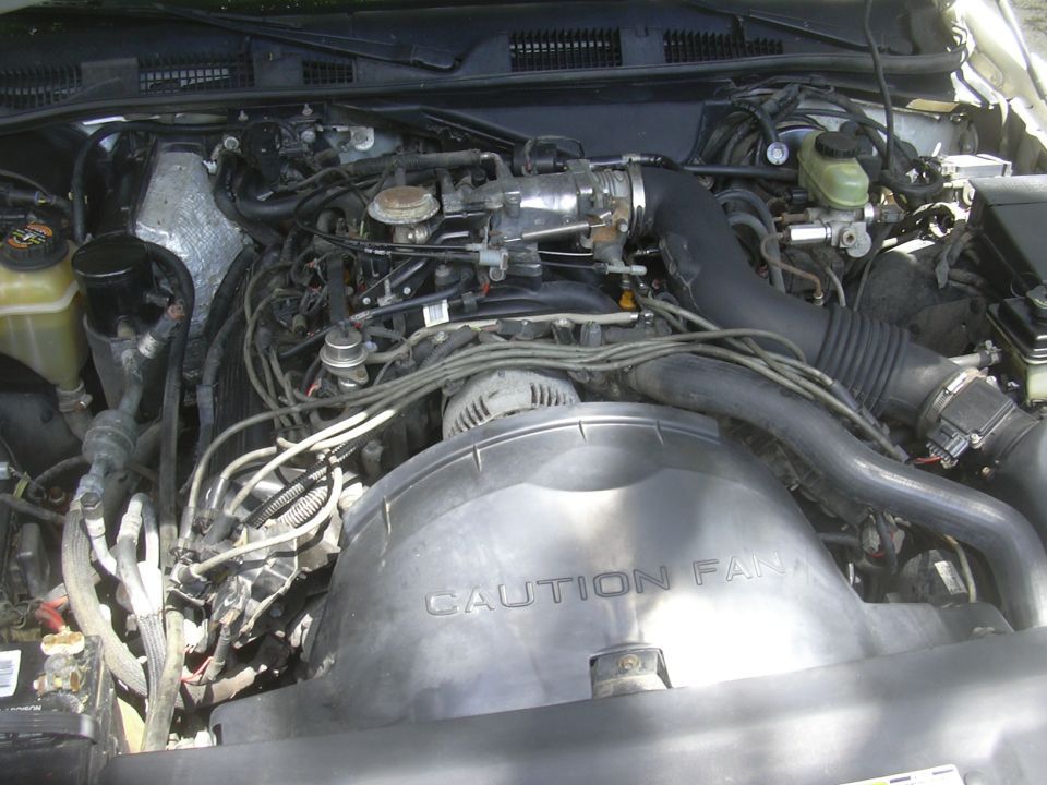 Engine bay with "CAUTION FAN" shroud and Supermotors.net logo