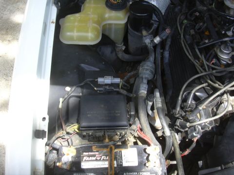 1997 Ford Crown Victoria - A close-up view of a car's engine compartment, showing the battery and associated components.