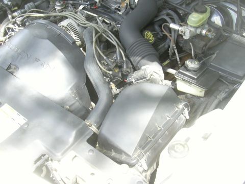 1997 Ford Crown Victoria - Close-up view of the engine bay, showing various components and a "CAUTION FAN" warning on the shroud.