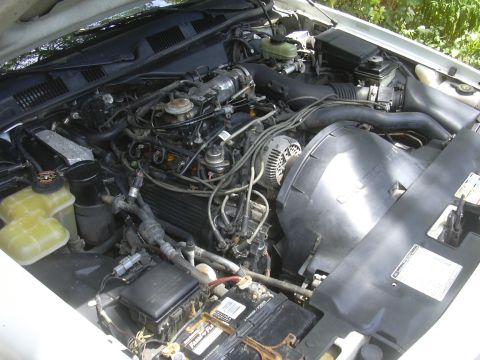 1997 Ford Crown Victoria - Close-up view of a vehicle's engine bay, showing mechanical components and wiring.