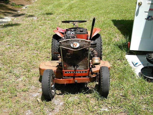 Front view of an orange riding lawn mower with a black grille and a visible engine